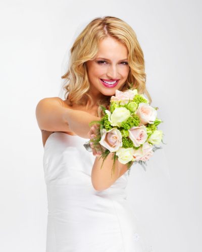 Its the perfect bouquet. Gorgeous young bride holding out her bouquet towards you - portrait
